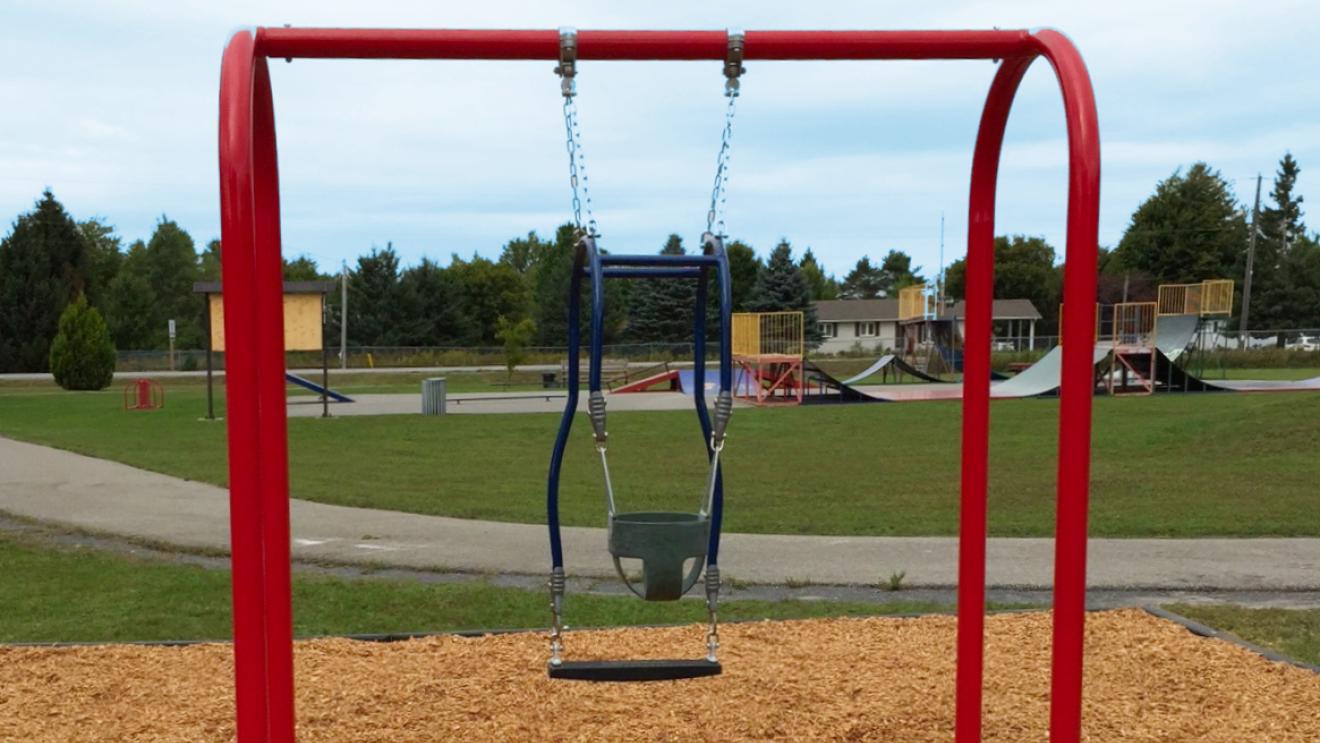 Accessible swing in the Latreille Park with the skate park in the background