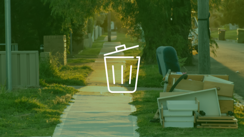 Large household items such as furniture and drawers placed at the curbside along a residential sidewalk for large item collection.