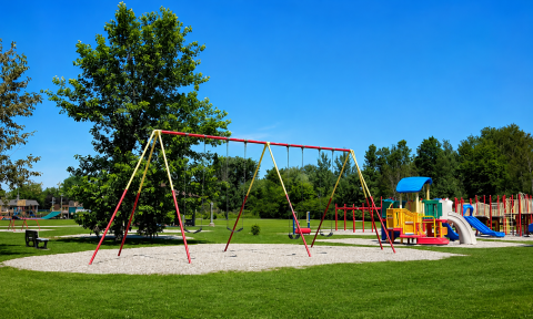 Play structures and swings on a summer day with bright blue skies